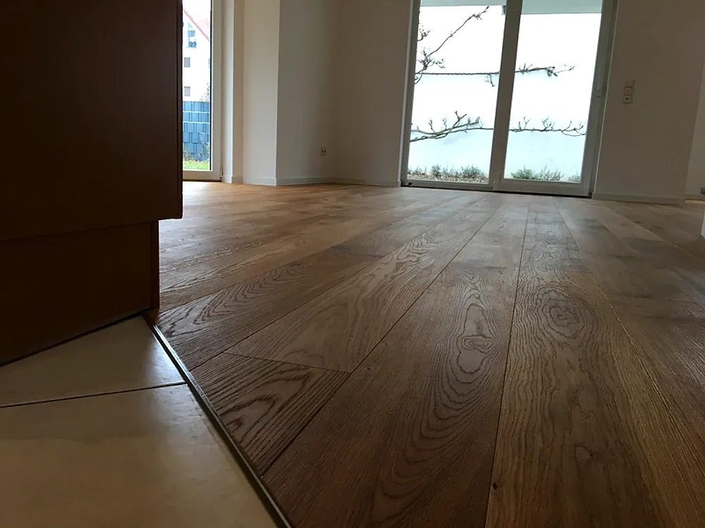 Wohnzimmer mit Eichendiele und Übergang zu Fliesen